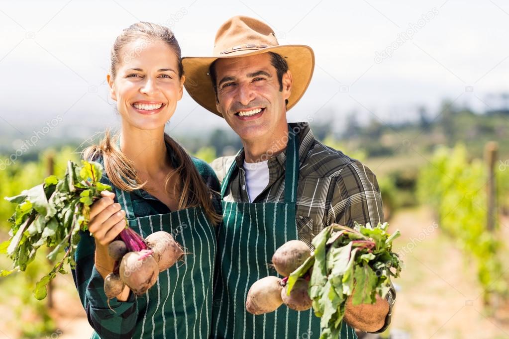 couple holding leafy vegetables
